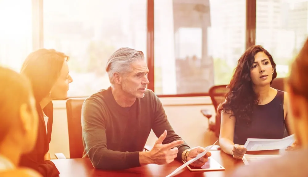 Een adviseur in gesprek met twee collega’s in een kantoor