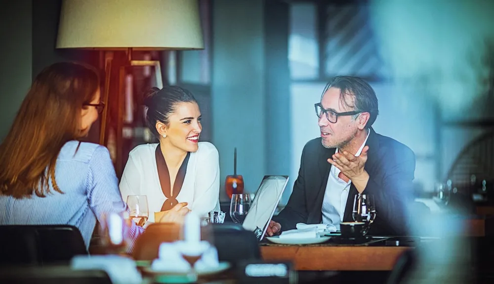 Een leidinggevende bespreekt een vraagstuk met collega’s aan een vergadertafel