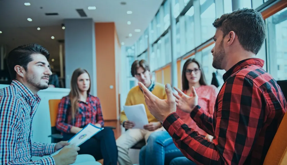 Collega’s in gesprek in een moderne werkruimte